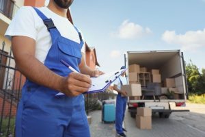 Two delivery man with card boxes and truck